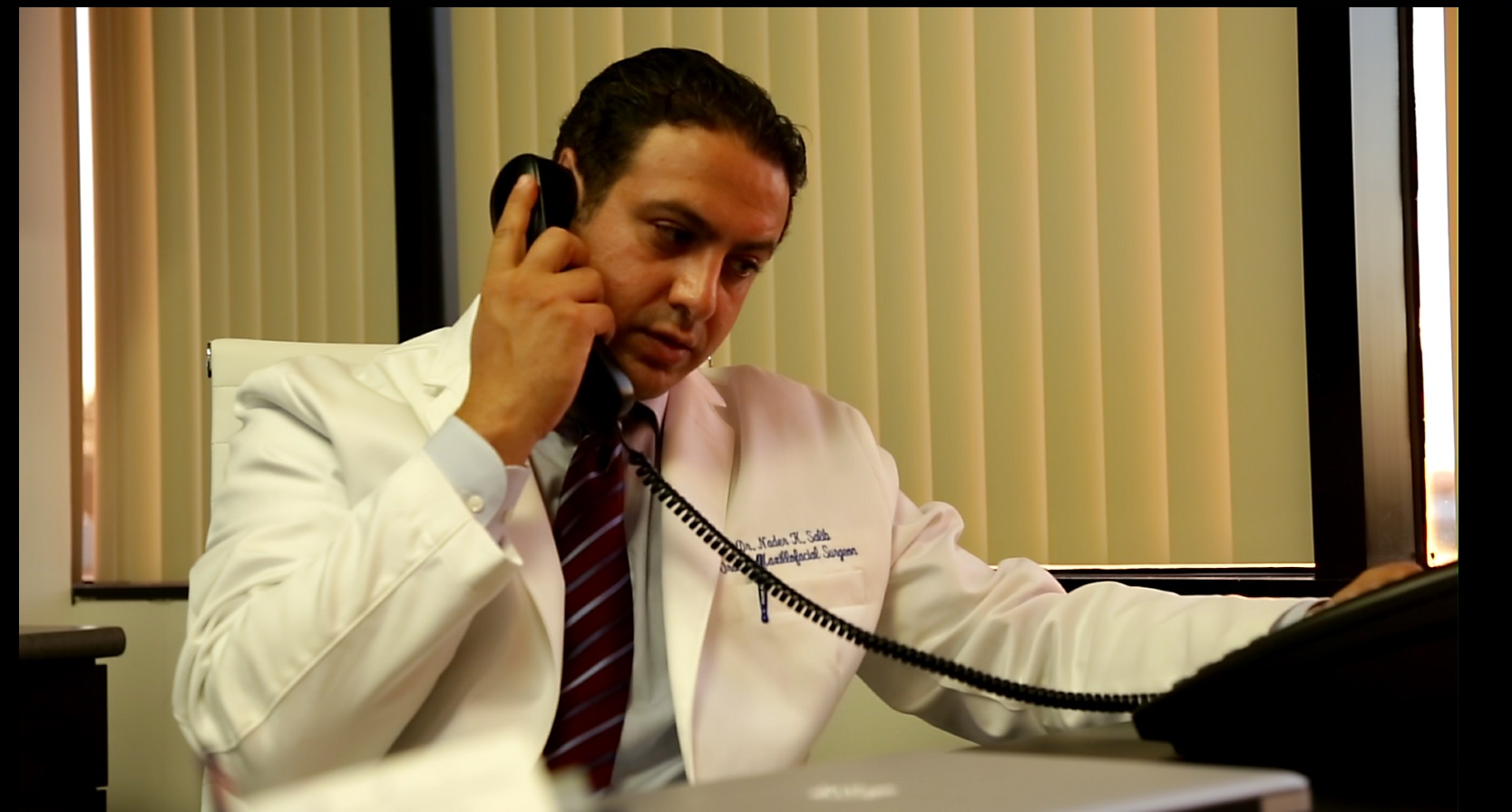 Dr. Nader Salib, DDS, board certified oral and maxillofacial surgeon, at his desk